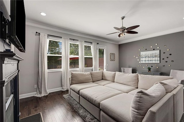 living area featuring crown molding, ceiling fan, a fireplace, baseboards, and dark wood-style floors