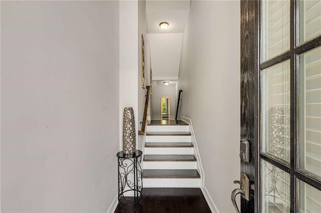 staircase featuring baseboards and wood finished floors