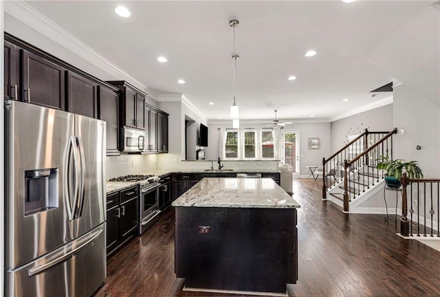 kitchen featuring decorative backsplash, a kitchen island, recessed lighting, a sink, and appliances with stainless steel finishes