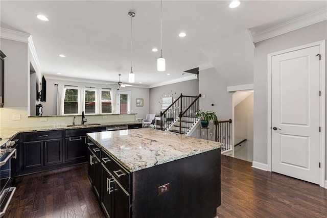 kitchen featuring decorative light fixtures, dark wood finished floors, a sink, light stone counters, and recessed lighting