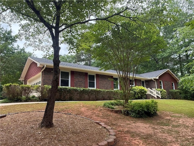 ranch-style house featuring brick siding, a garage, driveway, and a front lawn