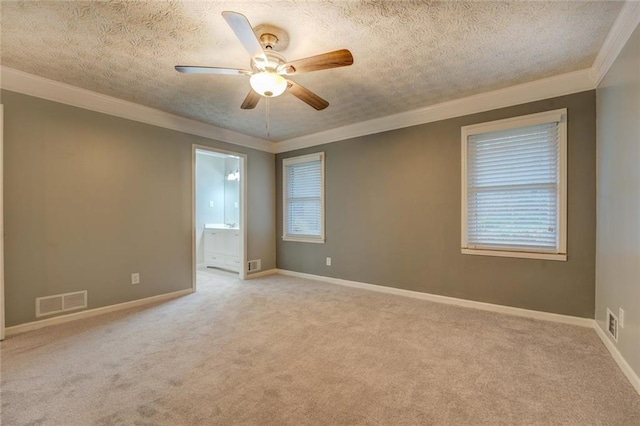 carpeted spare room with a ceiling fan, baseboards, a textured ceiling, and crown molding