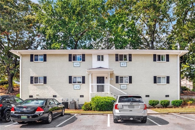 view of property featuring uncovered parking and central AC unit