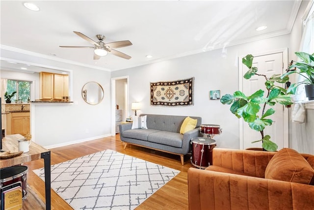 living room with ceiling fan, light wood-style floors, baseboards, crown molding, and recessed lighting