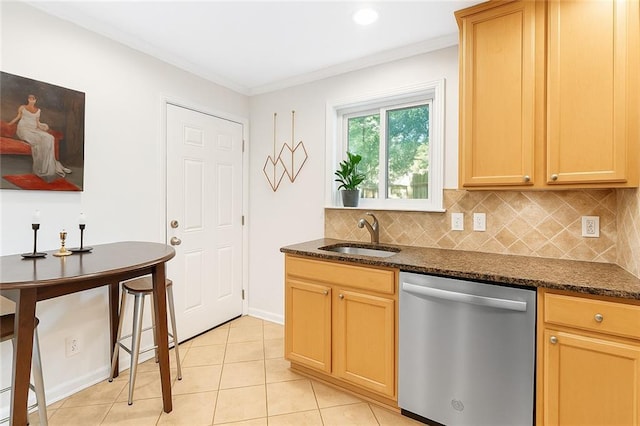 kitchen with stainless steel dishwasher, a sink, tasteful backsplash, crown molding, and dark stone countertops