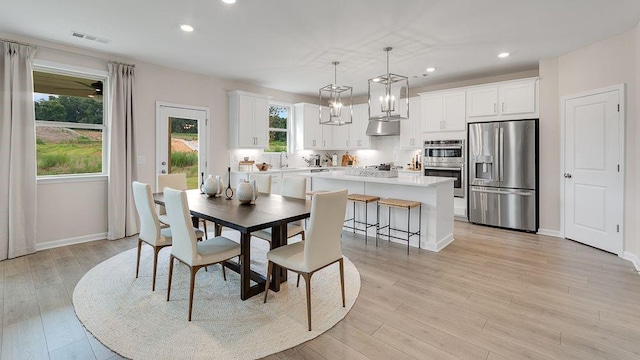 dining space with light wood-type flooring, baseboards, visible vents, and recessed lighting