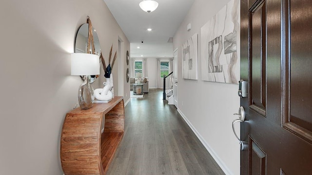 corridor featuring dark wood-type flooring, recessed lighting, and baseboards