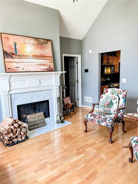3809 Autumn View Ln NW, Acworth, GA 30101 - living area featuring a high end fireplace, wood finished floors, and high vaulted ceiling
