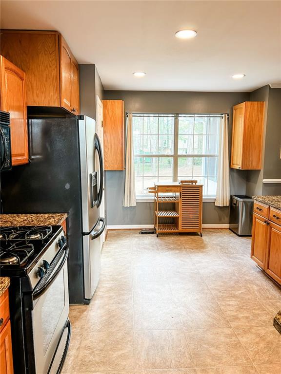 3809 Autumn View Ln NW, Acworth, GA 30101 - kitchen with gas range, brown cabinetry, recessed lighting, black microwave, and dark stone countertops
