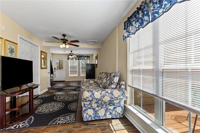 living room featuring ceiling fan, baseboards, and wood finished floors