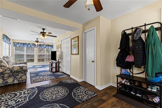 interior space with baseboards, a ceiling fan, and wood finished floors