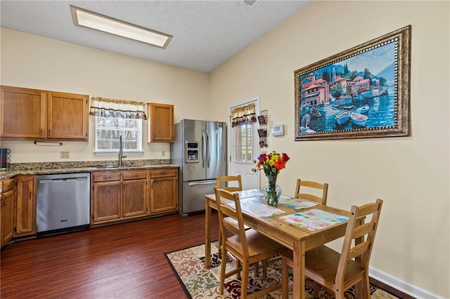 dining space with baseboards, a textured ceiling, and dark wood finished floors