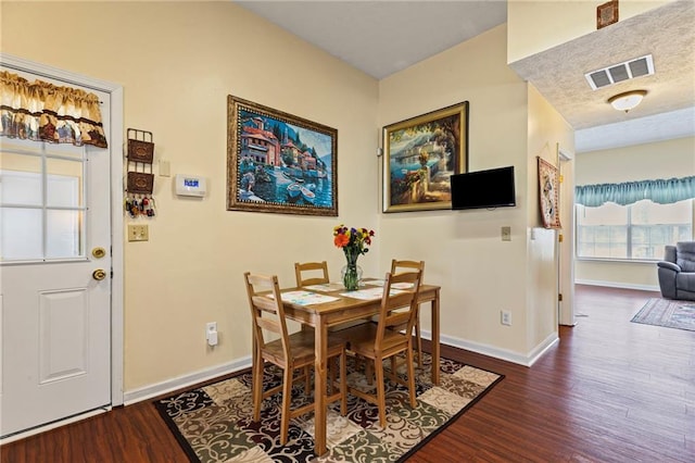 dining room featuring visible vents, baseboards, and wood finished floors