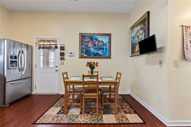 dining area featuring dark wood finished floors and baseboards