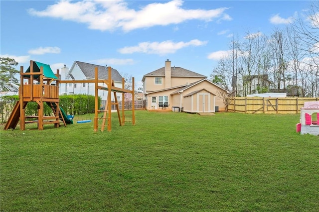 view of play area with a fenced backyard, a lawn, a storage shed, and an outdoor structure