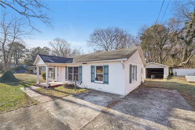 view of front facade with a front yard, a garage, and an outbuilding