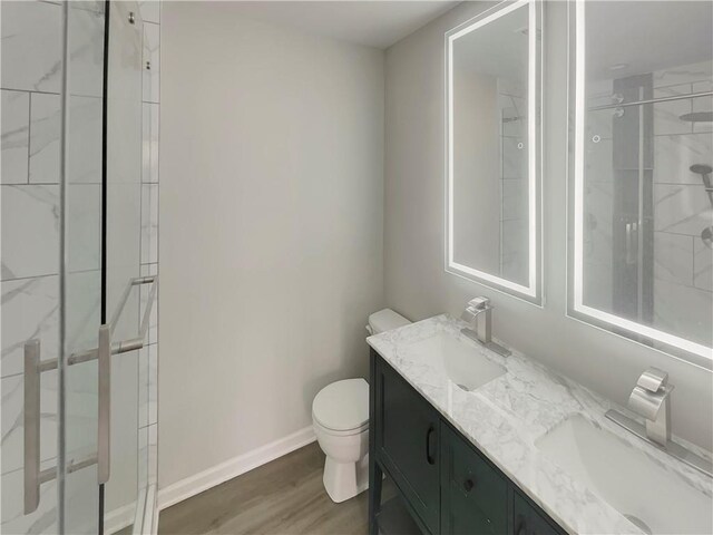 6941 Gallant Cir SE Unit 10, Mableton, GA 30126 - bathroom featuring toilet, a sink, tiled shower, and wood finished floors