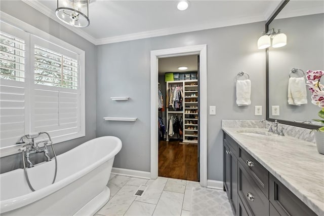 bathroom featuring ornamental molding, a bathing tub, and vanity