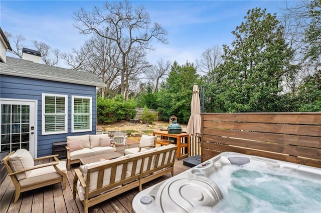 wooden deck with an outdoor living space and a hot tub