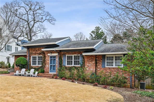 view of front of property with a front lawn and central air condition unit