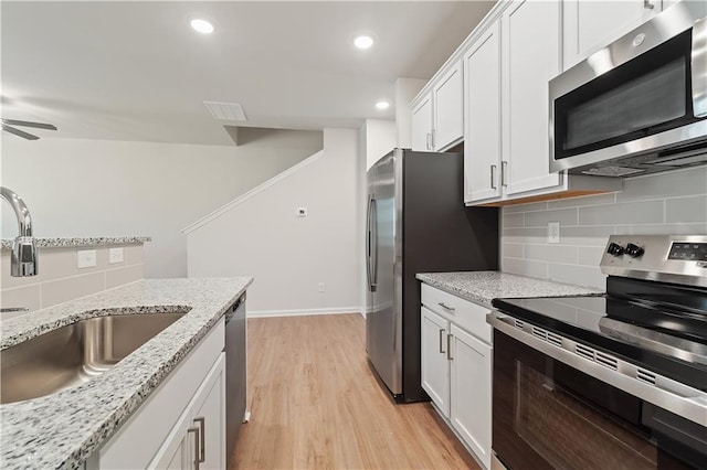 kitchen with white cabinets, stainless steel appliances, light hardwood / wood-style flooring, and sink