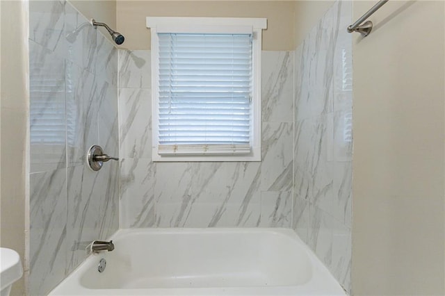 bathroom featuring tiled shower / bath and toilet