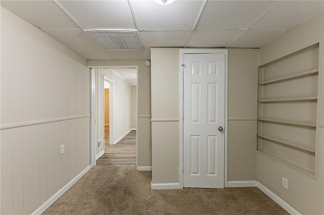 interior space featuring a paneled ceiling and carpet