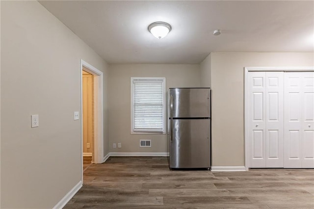 kitchen with wood-type flooring and stainless steel refrigerator