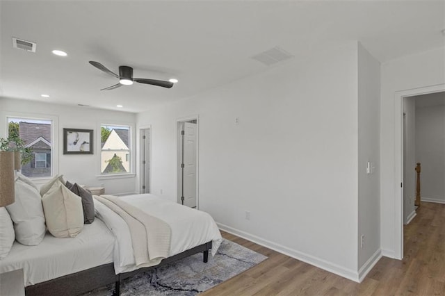 bedroom with visible vents, wood finished floors, and baseboards
