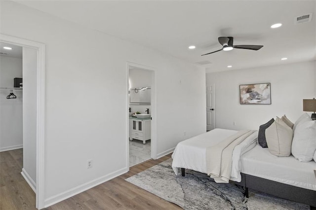 bedroom featuring recessed lighting, a spacious closet, visible vents, and wood finished floors