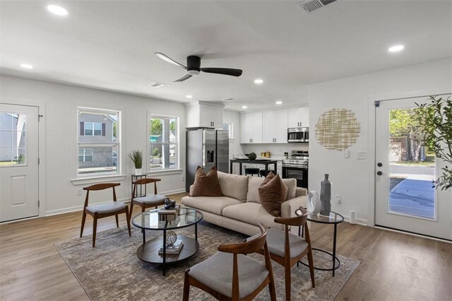 living area featuring a ceiling fan, light wood-style flooring, recessed lighting, baseboards, and visible vents