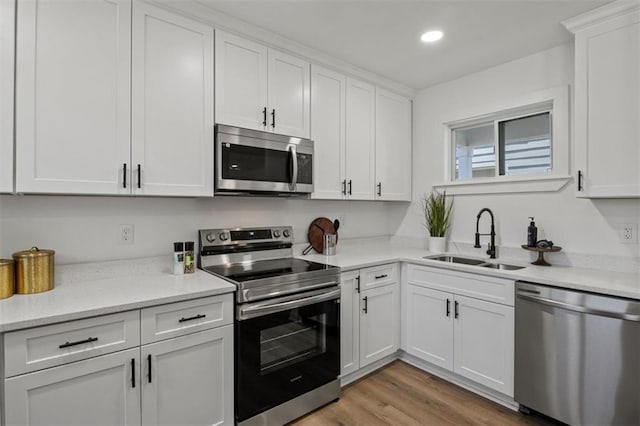 kitchen featuring a sink, recessed lighting, white cabinetry, and appliances with stainless steel finishes