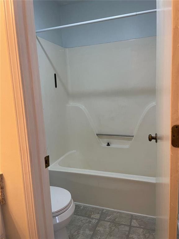 bathroom with bathing tub / shower combination and toilet