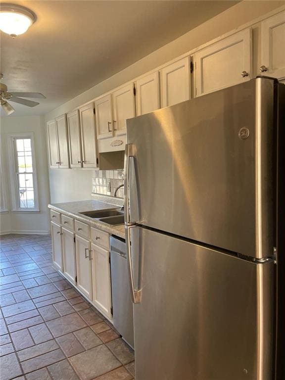 kitchen featuring white cabinets, ceiling fan, stainless steel appliances, light countertops, and a sink