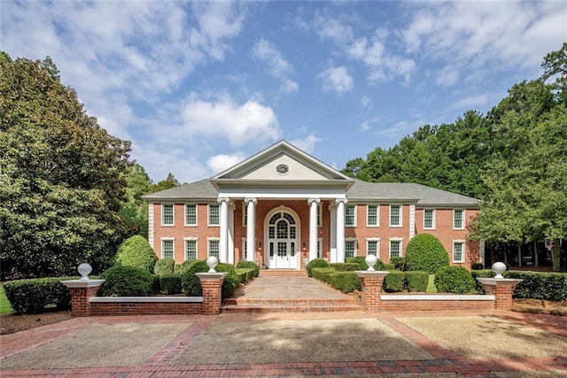 neoclassical home featuring french doors and covered porch