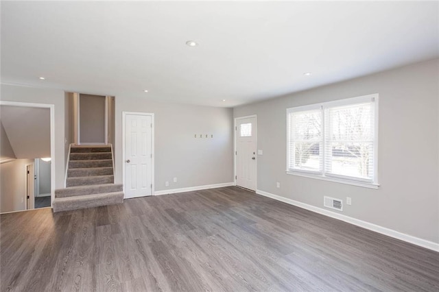 unfurnished living room with baseboards, visible vents, wood finished floors, stairs, and recessed lighting