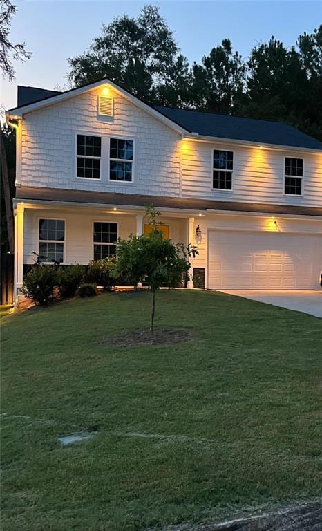 view of front facade featuring a garage and a yard