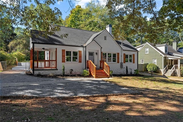 view of front of house featuring roof with shingles, brick siding, and a chimney