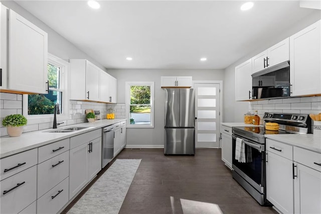 kitchen featuring appliances with stainless steel finishes, light countertops, dark wood-type flooring, and a sink