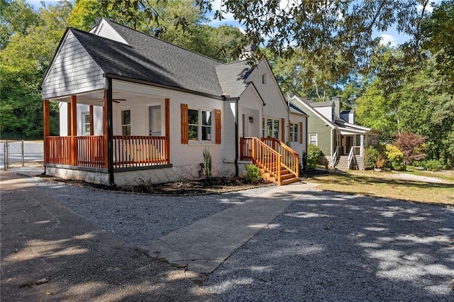 view of front of property with ceiling fan, brick siding, and roof with shingles