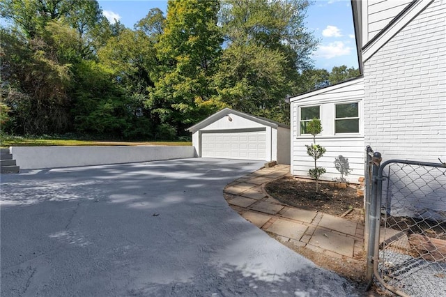 exterior space featuring a garage, brick siding, and an outdoor structure