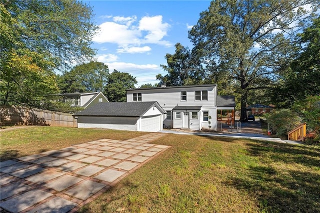 rear view of house with an outbuilding, a yard, concrete driveway, fence, and a garage