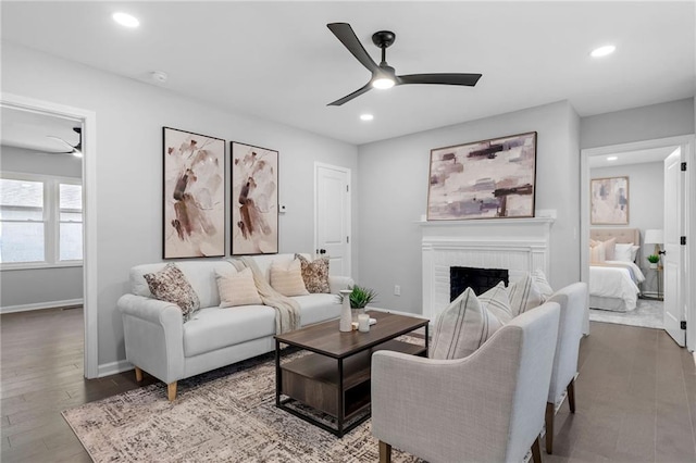 living area featuring a ceiling fan, recessed lighting, a brick fireplace, and wood finished floors