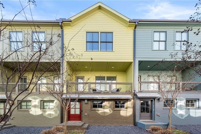 townhome / multi-family property featuring brick siding and a balcony