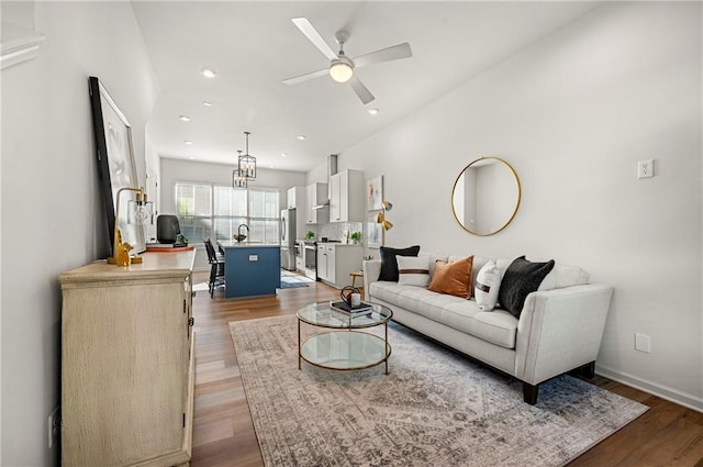 living room featuring a ceiling fan, recessed lighting, wood finished floors, and baseboards