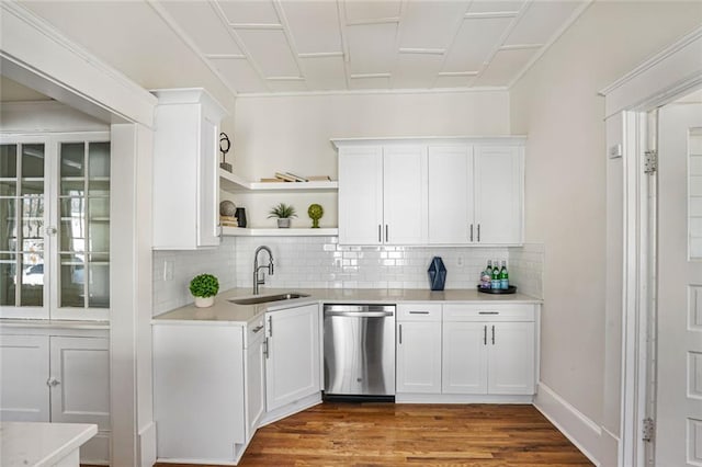 bar featuring a sink, backsplash, dishwasher, and wood finished floors