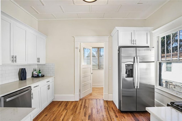 kitchen featuring stainless steel appliances, plenty of natural light, backsplash, and wood finished floors