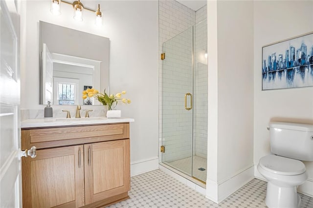 full bathroom with a stall shower, baseboards, vanity, and toilet