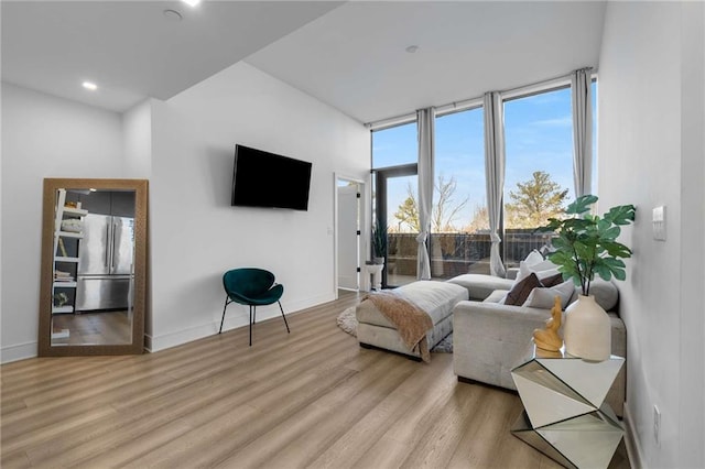 living area with baseboards and light wood finished floors