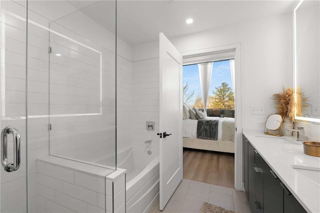 ensuite bathroom featuring a tub to relax in, tile patterned floors, an enclosed shower, and ensuite bath